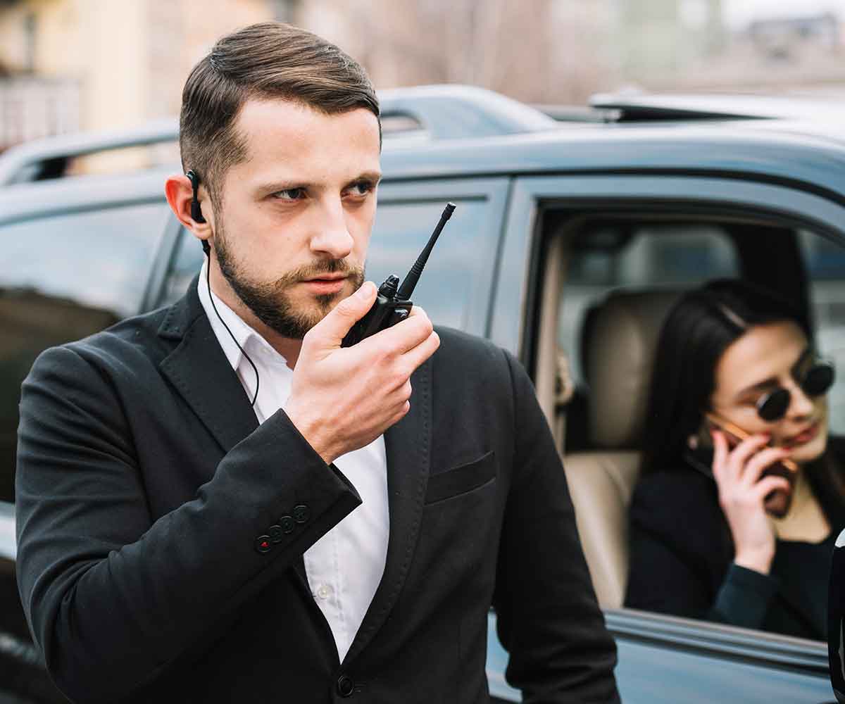 Security professionals using radios beside a vehicle